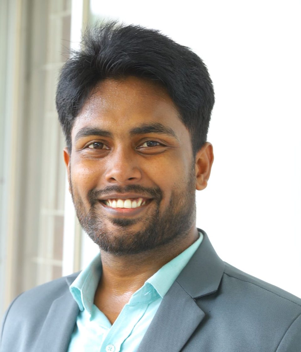Portrait of Md. Mahabub Mia, smiling, wearing a grey blazer and light blue shirt